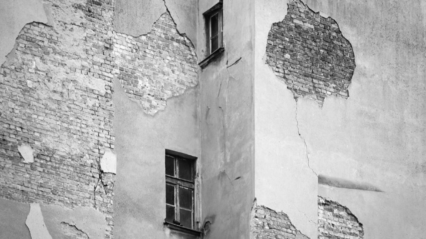 Vecchio edificio con crepe nella facciata. Concetto tradizionale vs digitale